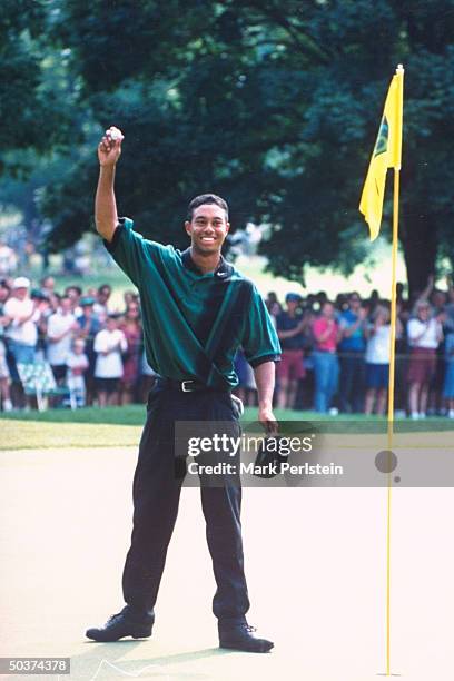 Greater Milwaukee Open. Tiger Woods in action alone, victioriously holding up ball after hole-in-one at Brown Deer Park GC.