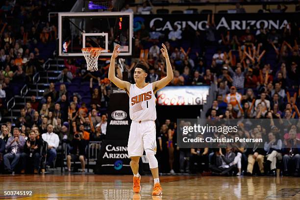 Devin Booker of the Phoenix Suns reacts after the Suns scored against the Charlotte Hornets during the second half of the NBA game at Talking Stick...
