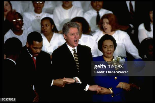 President Bill Clinton singing 'We Shall Overcome' and holding hands with Dexter King & Coretta Scott King, son & widow of Rev. Martin Luther King...