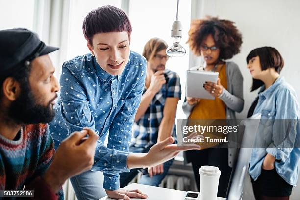 jóvenes profesionales trabajando juntos en nuevo proyecto - hipster fotografías e imágenes de stock