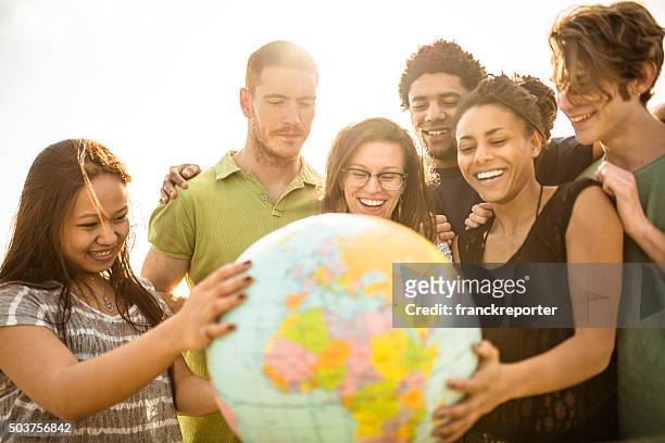 teenagers college student smiling with globe - charity education stock pictures, royalty-free photos & images
