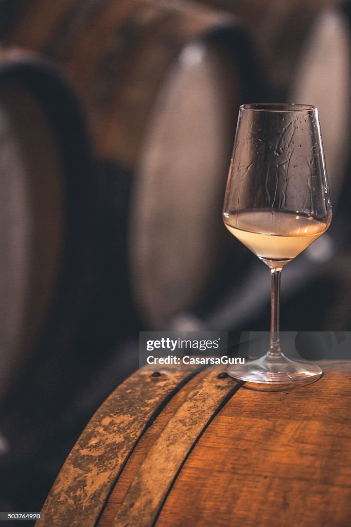 Glas Weißwein auf ein Barrel