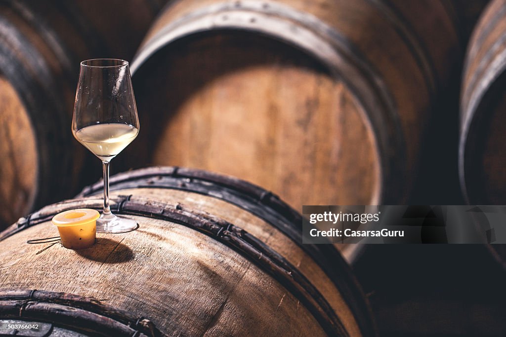 Glas Wein mit einem Holzfass