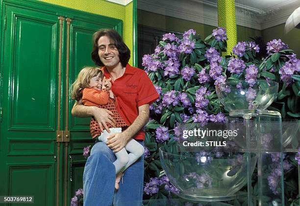 Le chanteur Michel Delpech portant sa fille dans les bras à Paris, France, circa 1970.