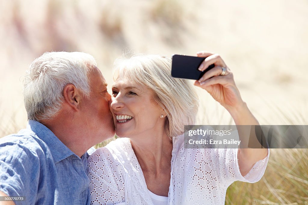 Mature couple taking a selfie on the beach