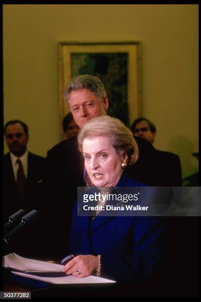 State Secy. Madeleine Albright speaking, Pres. Bill Clinton poised behind her, during her swear-in ceremony in White House Oval Office.