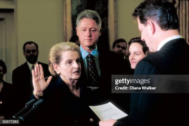 State Secy. Madeleine Albright raising hand, being sworn-in by VP Al Gore w. Her daughter & Pres. Bill Clinton in witness, in White House Oval Office...