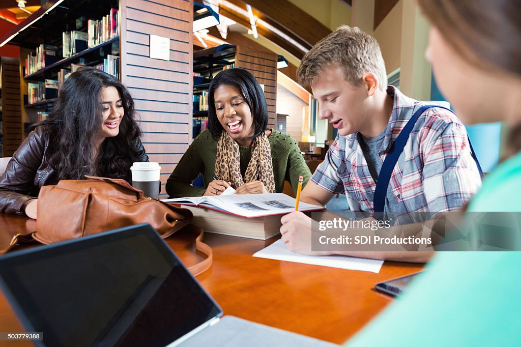 Diverse study group working on class assignment in library