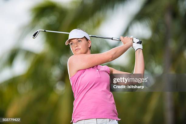 signora golfista giocando a tiro con palme sullo sfondo - woman on swing foto e immagini stock