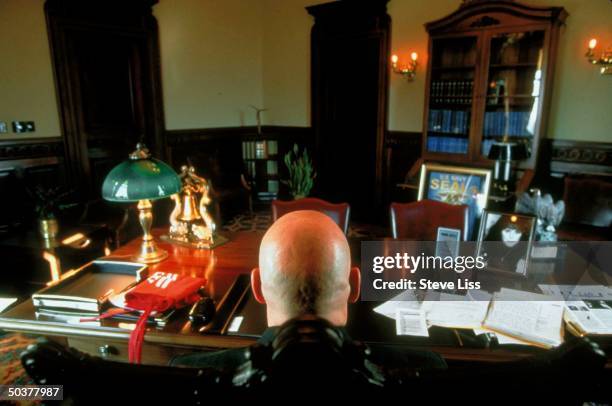 Rear view of former pro wrestler-turned-governor Jesse The Body Ventura sitting at his desk in the capital.