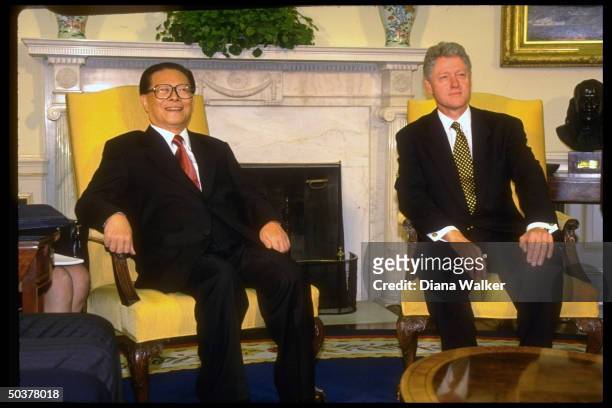Chinese Pres. Jiang Zemin & Pres. Bill Clinton mtg. In White House Oval Office, sitting in front of Swedish ivy-topped mantelpiece.