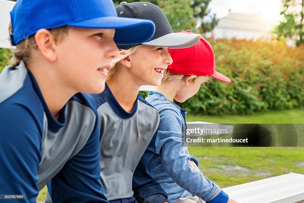 Três jovens irmãos assistir Jogo de Beisebol ao ar livre.