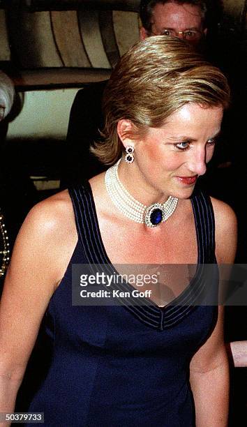 England's Princess Diana in a new sleek hairstyle, jeweled choker & earrings & navy blue strapped gown at a charity gala dinner at the Lincoln Center...