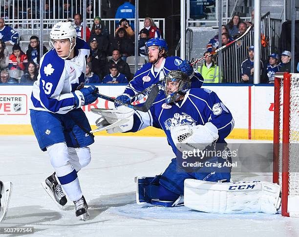Matt Frattin of the Toronto Marlies takes a stick from goalie Kristers Gudlevskis of the Syracuse Crunch during AHL game action on January 3, 2016 at...