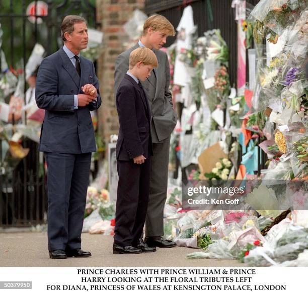 Britain's Prince Charles, Prince Harry and Prince William viewing flower tributes to Princess Diana outside Kensington Palace.