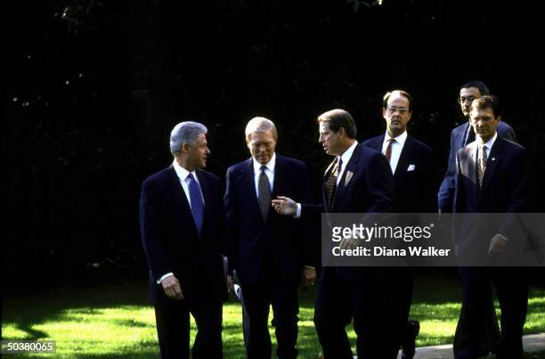 Pres. Bill Clinton, House Minority Leader Dick Gephardt & VP Al Gore pausing to confer on path from White House Oval Office followed by chief of...