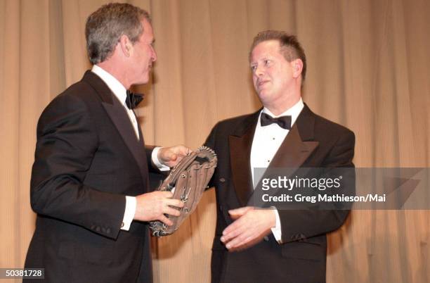 President George W. Bush receiving baseball glove from actor Darrell Hammond at the Annual Dinner of the White House Correspondents' Association at...