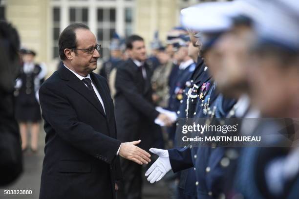 French President Francois Hollande shakes hands with French police forces at the police headquarters, in Paris, on January 7 exactly one year after...