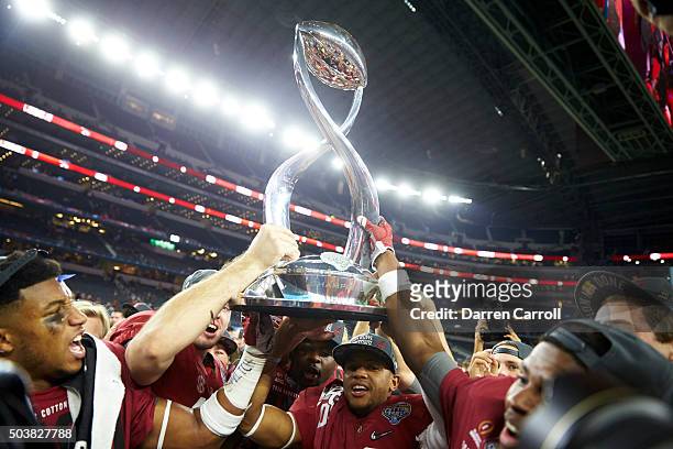 Cotton Bowl: Alabama players victorious holding up trophy after winning College Football Playoff Semifinal game vs Michigan State at AT&T Stadium....