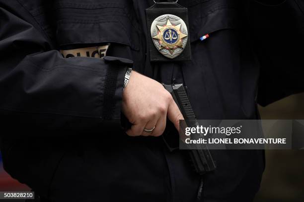 Police officer of the French national police stands armed near the Rue de la Goutte d'Or in the north of Paris on January 7 after police shot a man...