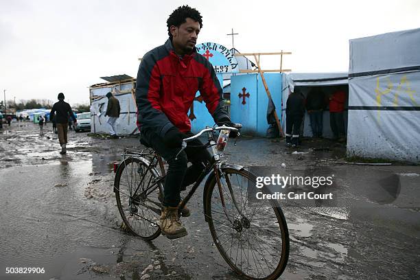 An Eritrean Orthodox Christian man cycles away after attending a Christmas service at a church in the camp known as 'The Jungle' on January 7, 2016...