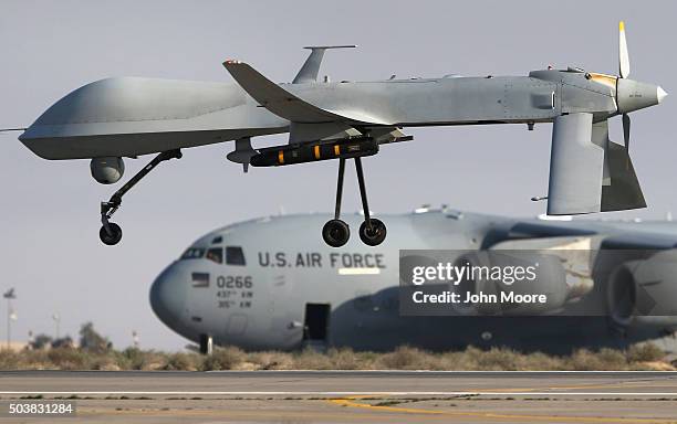 Air Force MQ-1B Predator unmanned aerial vehicle , carrying a Hellfire air-to-surface missile lands at a secret air base in the Persian Gulf region...