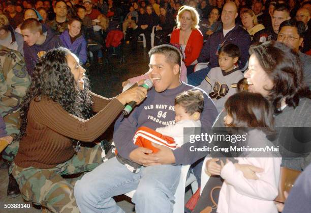 Singer Ruth Pointer , formerly of the Pointer Sisters, singing to a US serviceman and his family in the audiance of a USO show during the USO Holiday...