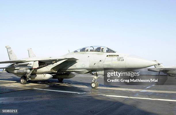 An F-14 Tomcat fr. The Checkmates of Fighter Squadron Two One One maneuvering the flight deck while taxiing prior to positioning for launch. The...