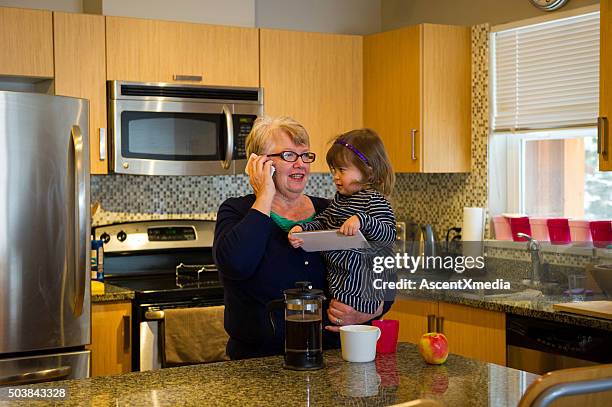 grandma and toddler using a tablet - busy toddlers stock pictures, royalty-free photos & images