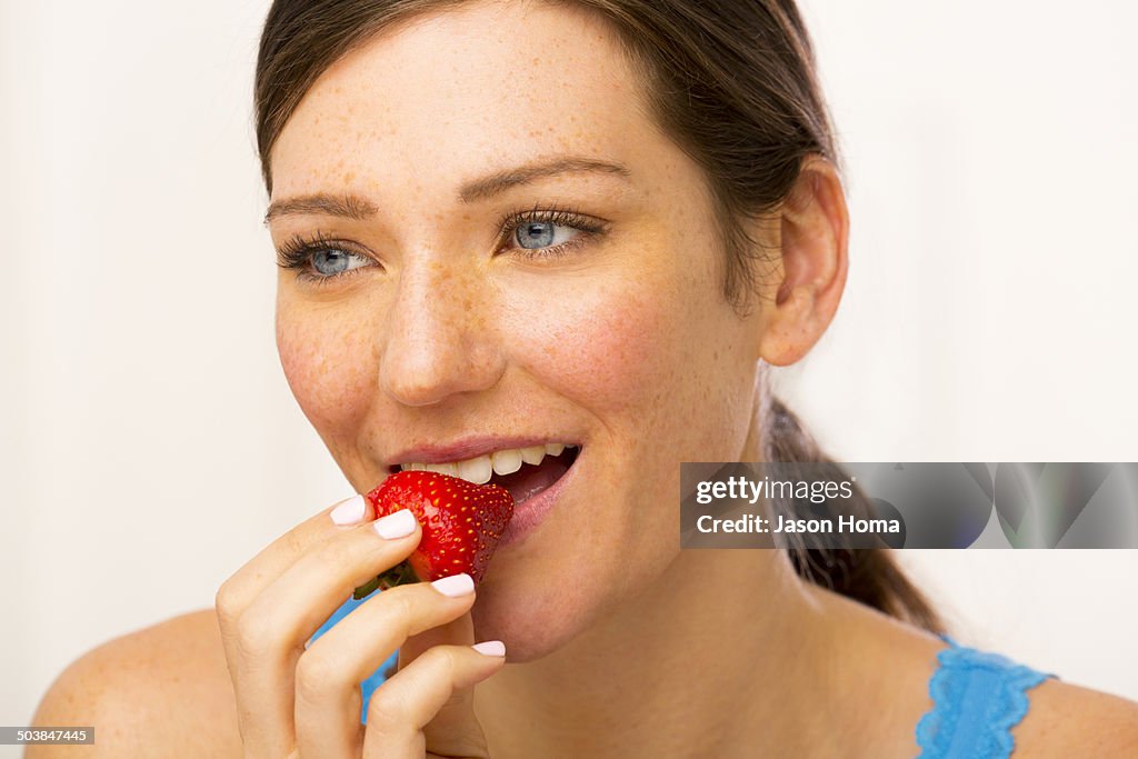 Caucasian woman eating strawberry