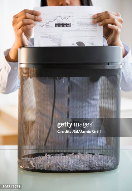mixed race businesswoman shredding documents - paper shredder stock pictures, royalty-free photos & images