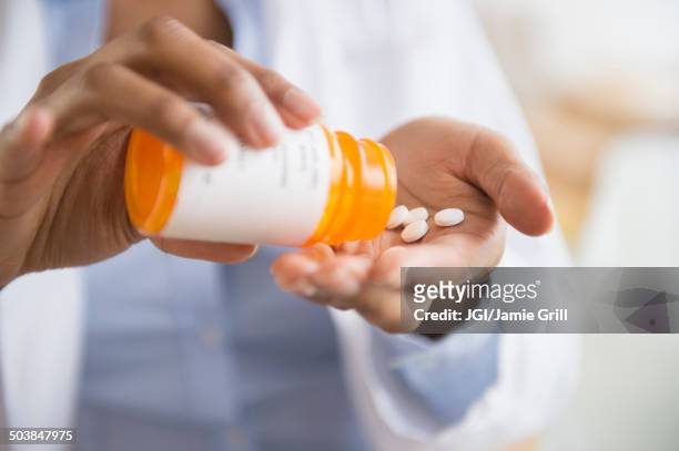 mixed race doctor taking medication - prescription medicine stock pictures, royalty-free photos & images