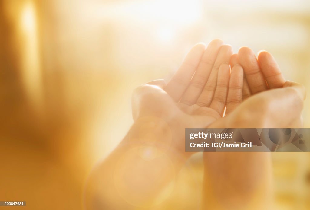 Mixed race woman holding out cupped hands