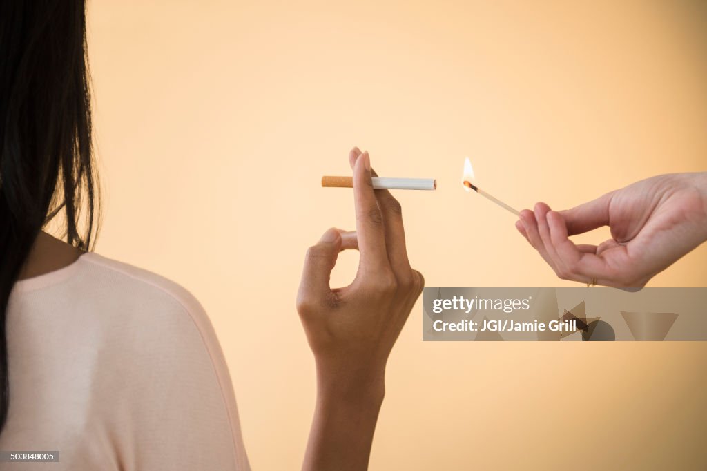 Man lighting woman's cigarette