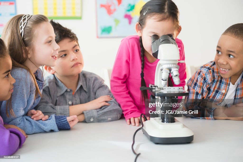 Students using microscope in classroom