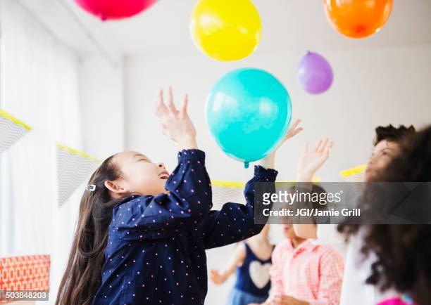 children playing with colorful balloons at party - kids party balloons stock-fotos und bilder
