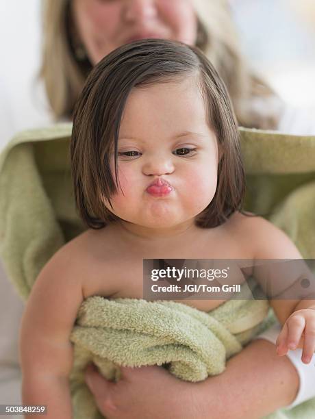 hispanic toddler making faces after bath - down syndrome baby stockfoto's en -beelden