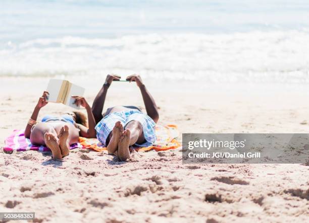 couple relaxing together on beach - beach book reading stock pictures, royalty-free photos & images