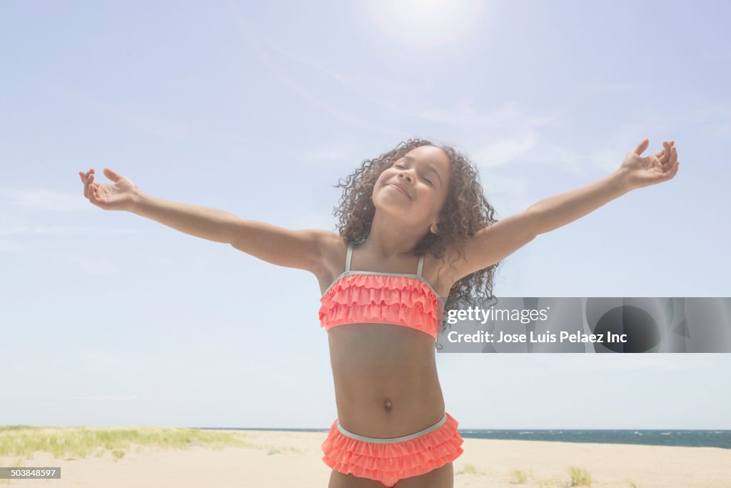 Mixed race girl playing on beach