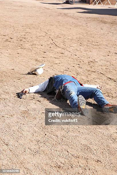 dead gunman - dead body sand stock pictures, royalty-free photos & images