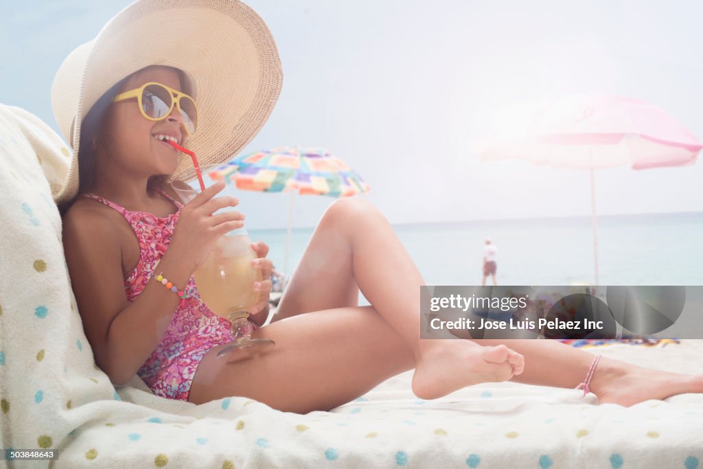 Girl relaxing in lounge chair on beach