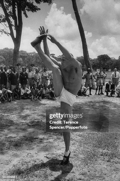 Track runner, Mal Whitfield, giving exercising demonstrations, while visiting a native village during his trip to Zambia.