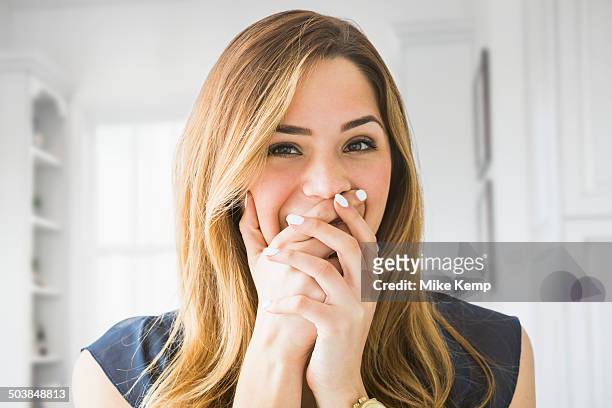 mixed race woman covering her mouth at home - hand over bildbanksfoton och bilder