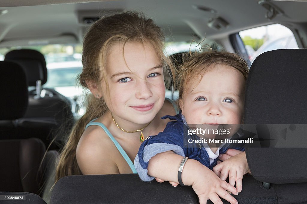 Caucasian children sitting in backseat of car