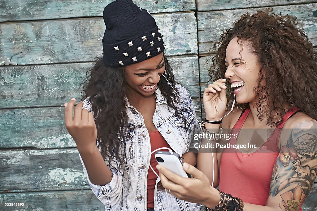 Women listening to mp3 player on city street