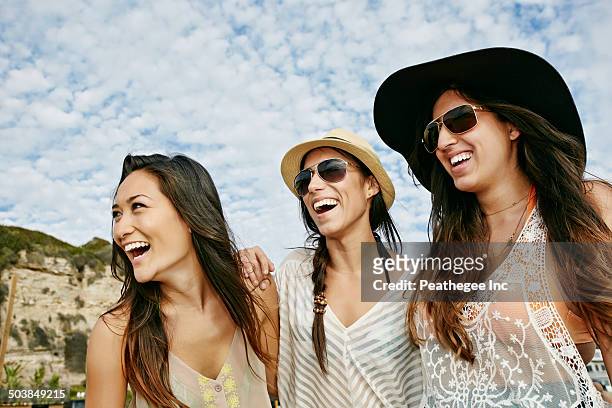 women smiling together on beach - white people laughing stock pictures, royalty-free photos & images