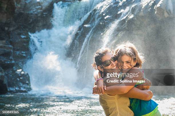 mother and daughter hugging by waterfall - hot mexican girls stock-fotos und bilder