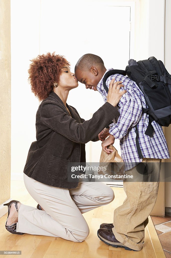 African American mother getting son ready for school