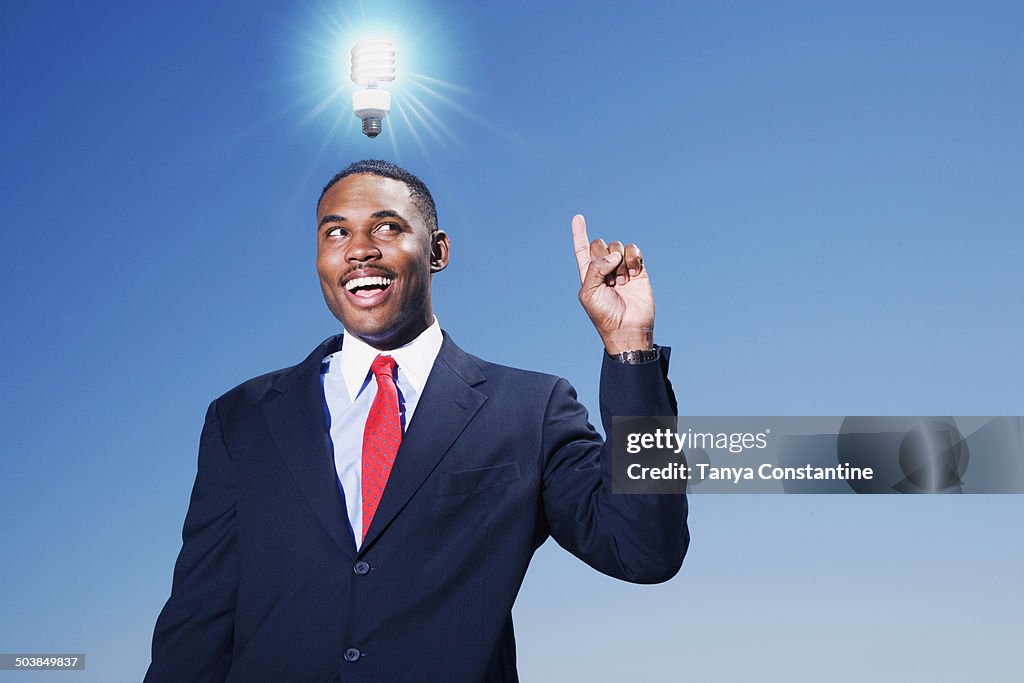 Mixed race businessman with light bulb over his head