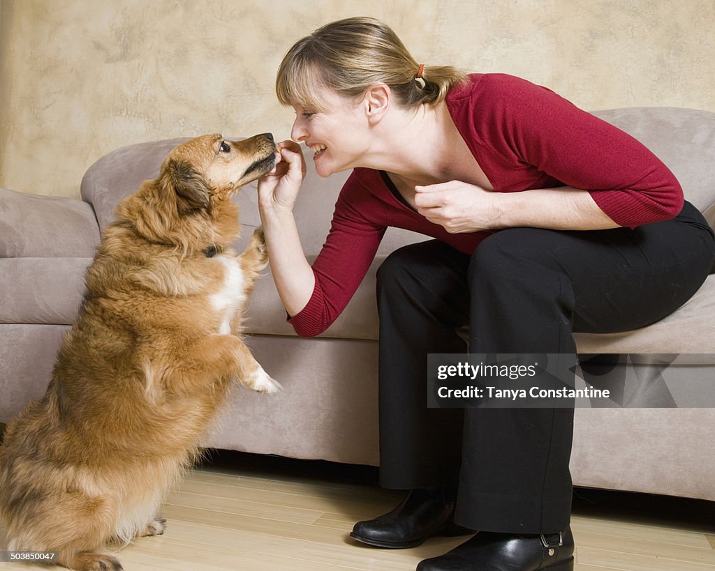 Caucasian woman feeding dog treat